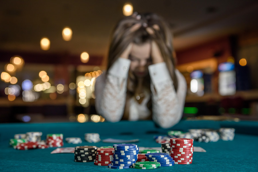 Woman holding her head down at a casino table
